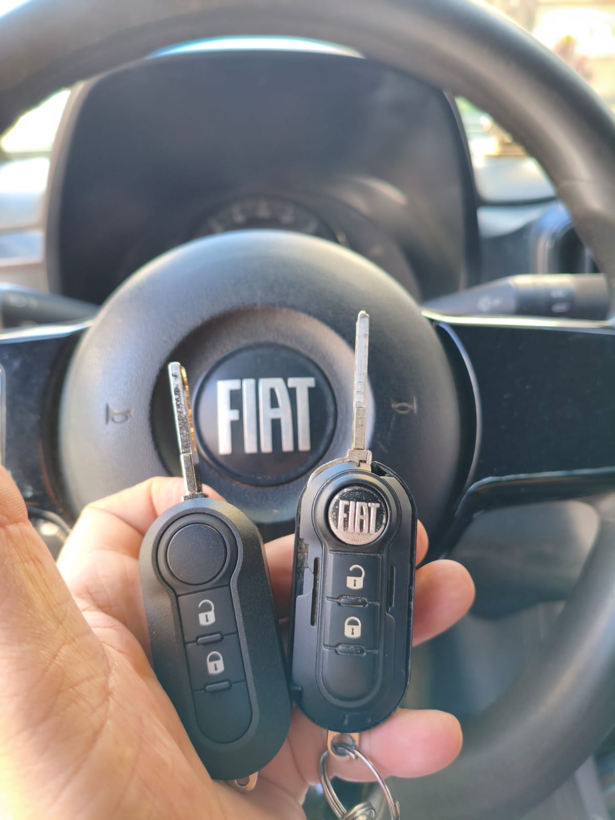 Duas chaves Fiat no volante do carro, prontas
