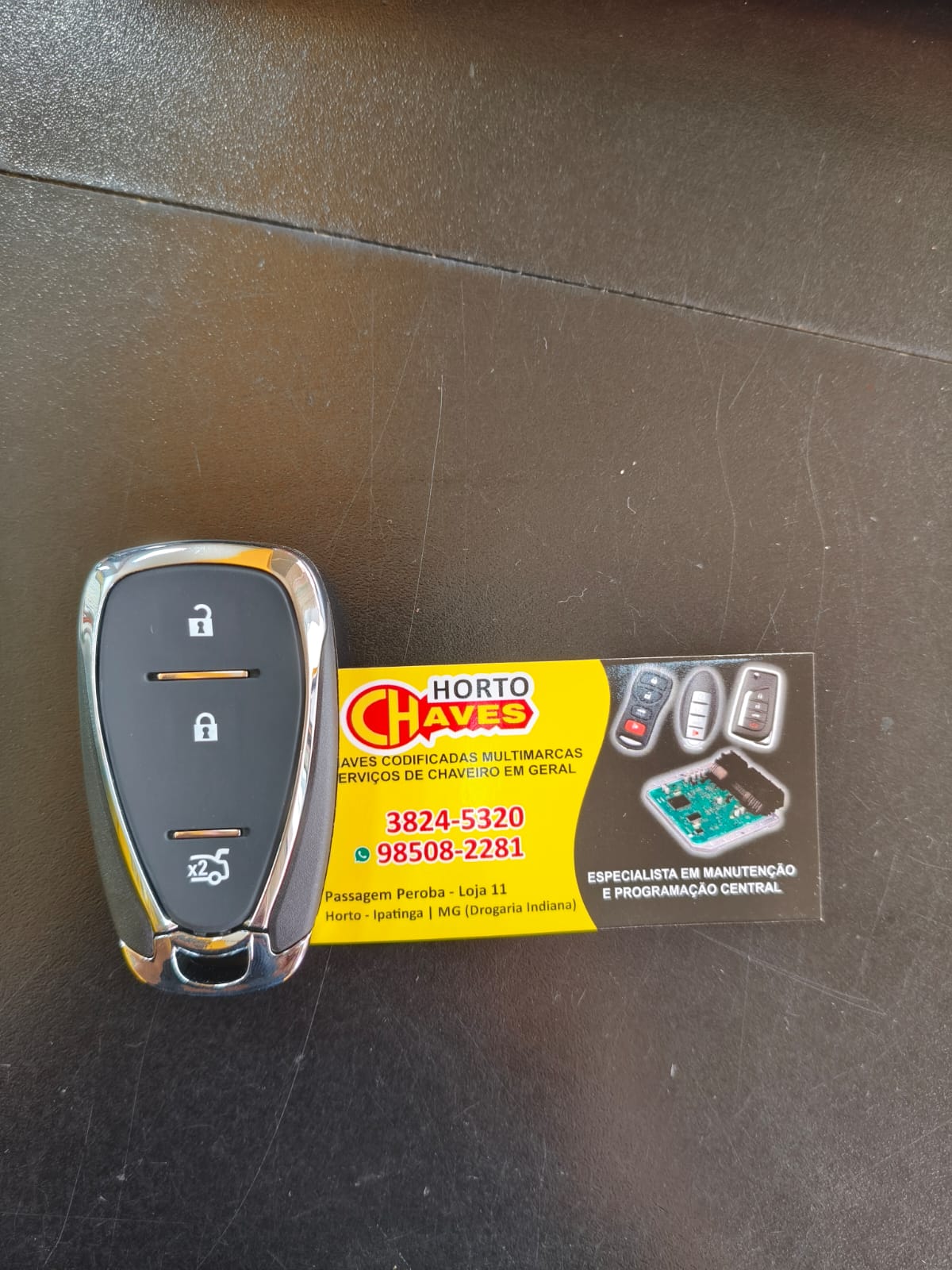 Chave canivete Chevrolet ao lado do cartão da Horto Chaves